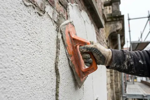 Sierpleister met korrel die met de plastic spaan wordt geschuurd